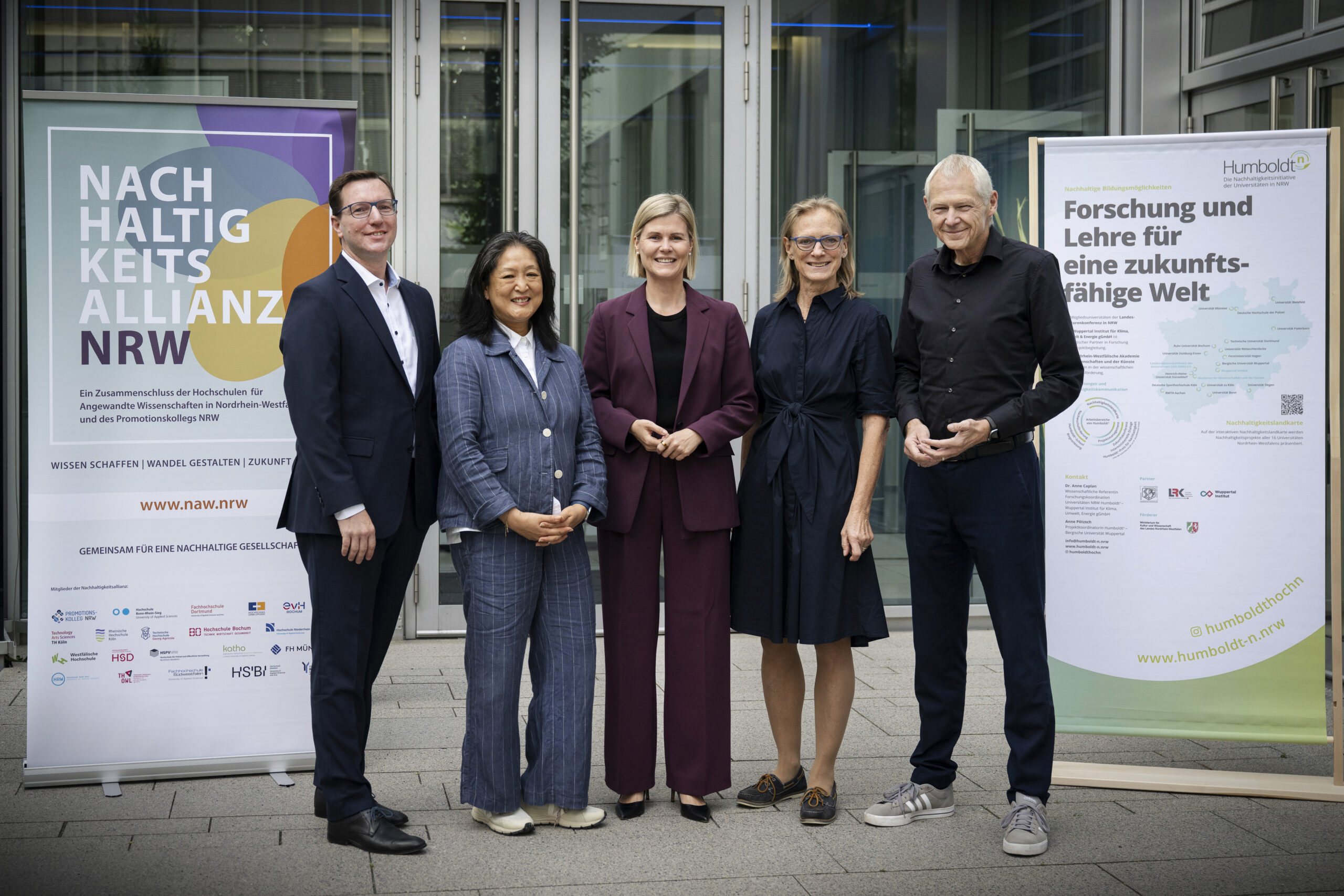 © bettina engel-albustin | fotoagentur-ruhr moers Drei Frauen und zwei Männer stehen vor einer Glasfront und lächeln in die Kamera, links und rechts von ihnen steht jeweils ein Roll-Up.